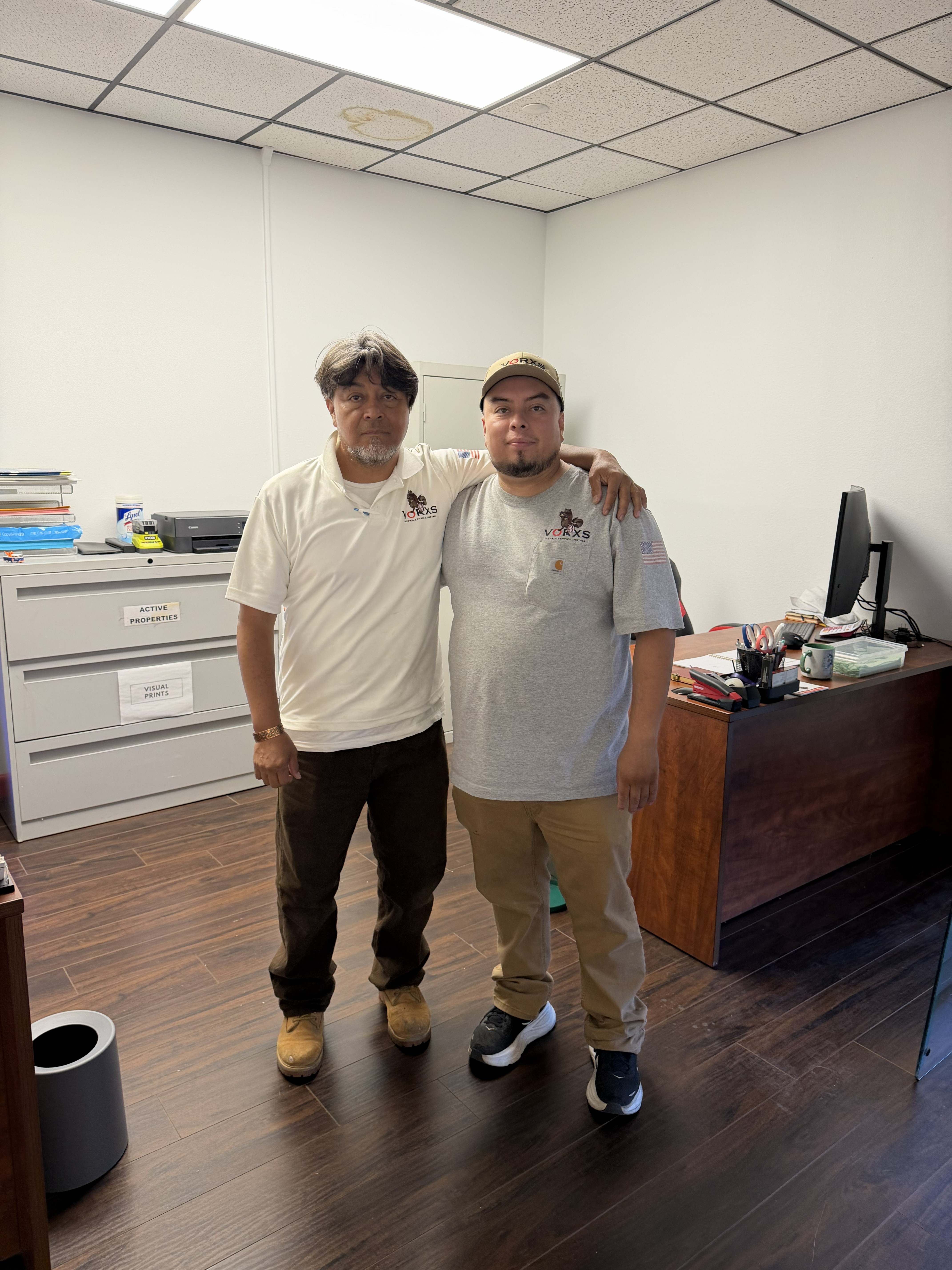 Albert Jr. and his father standing together at VORXS Heating & Air Conditioning.