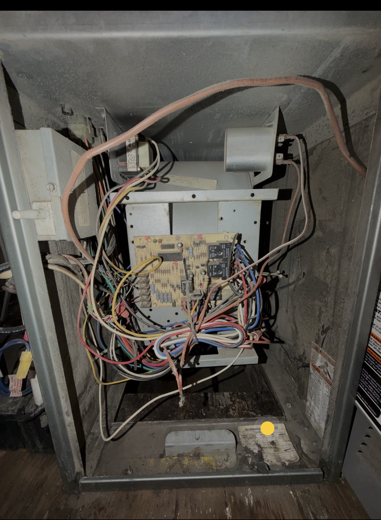 Older furnace control board and wiring inspected during HVAC service