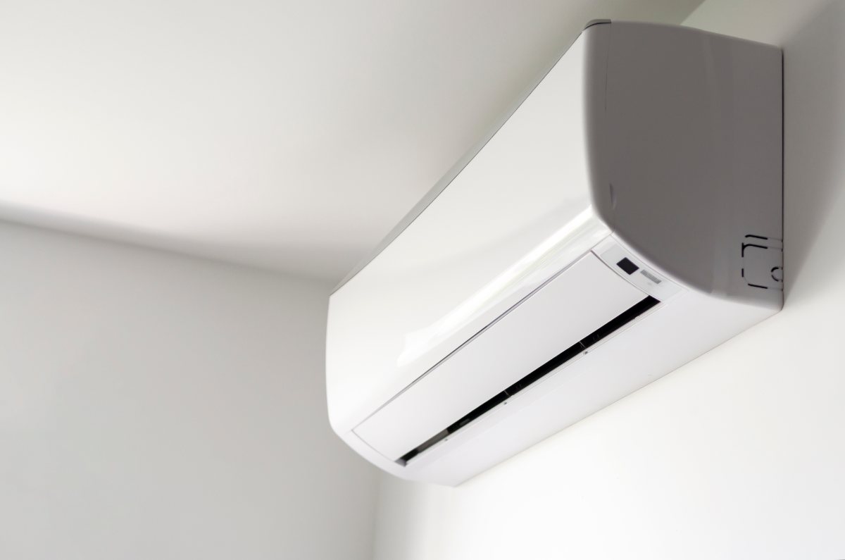 White ductless mini split indoor unit mounted high on a wall near the ceiling