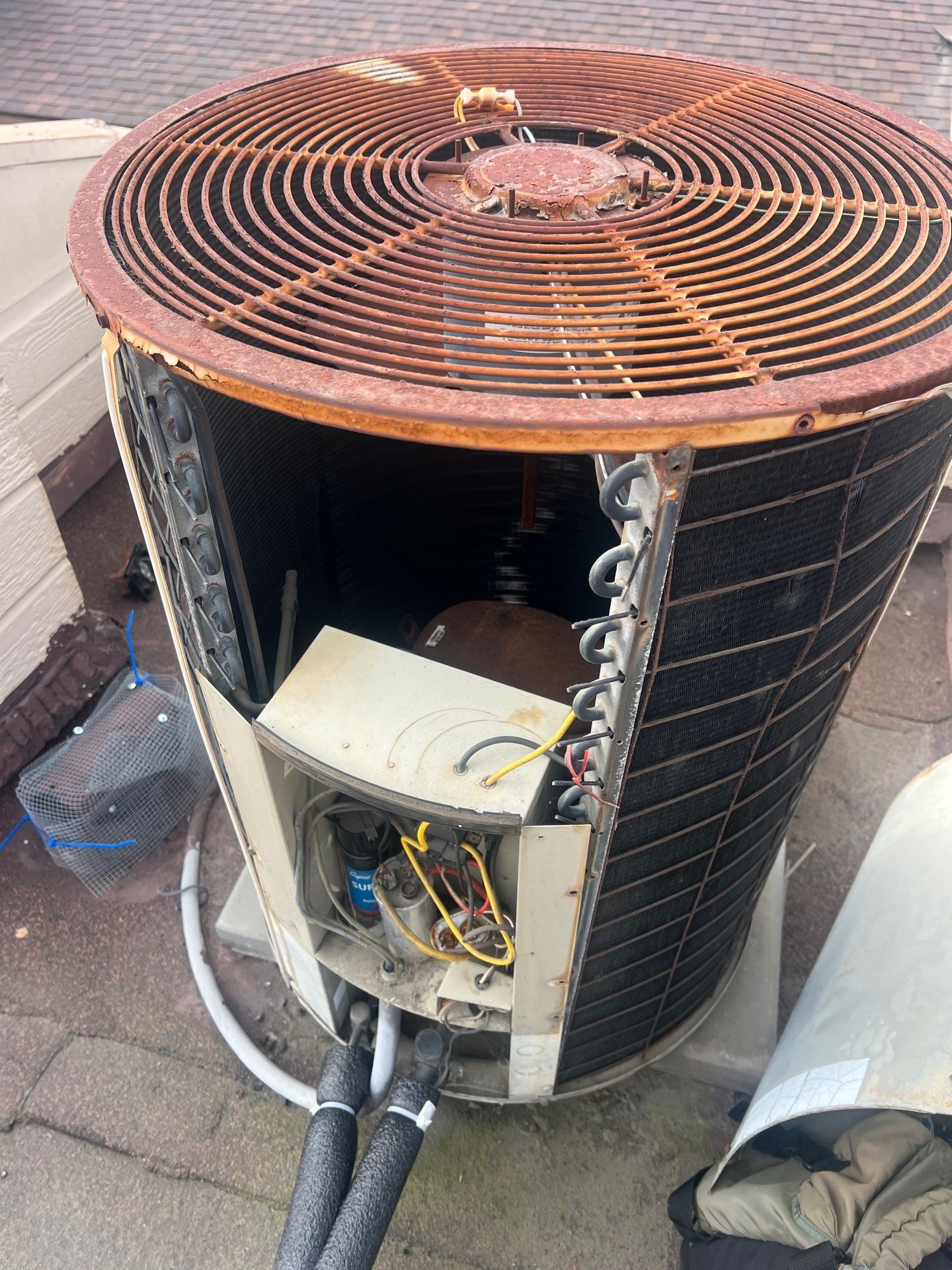 A heavily rusted, aging AC condenser with its panel open in Orange County