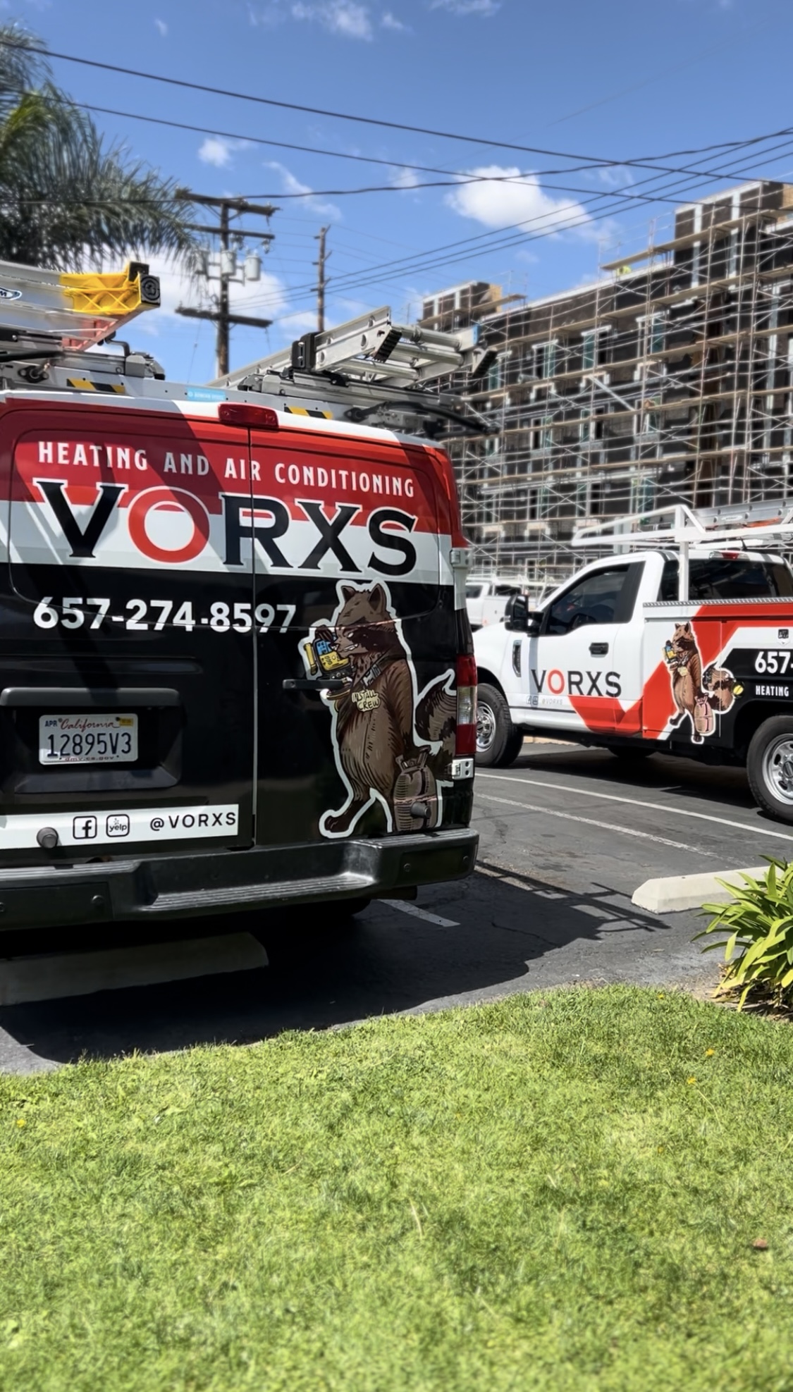 The VORXS install crew van and service truck on-site at an Orange County job — raccoon mascot decal, ladders, ready to work