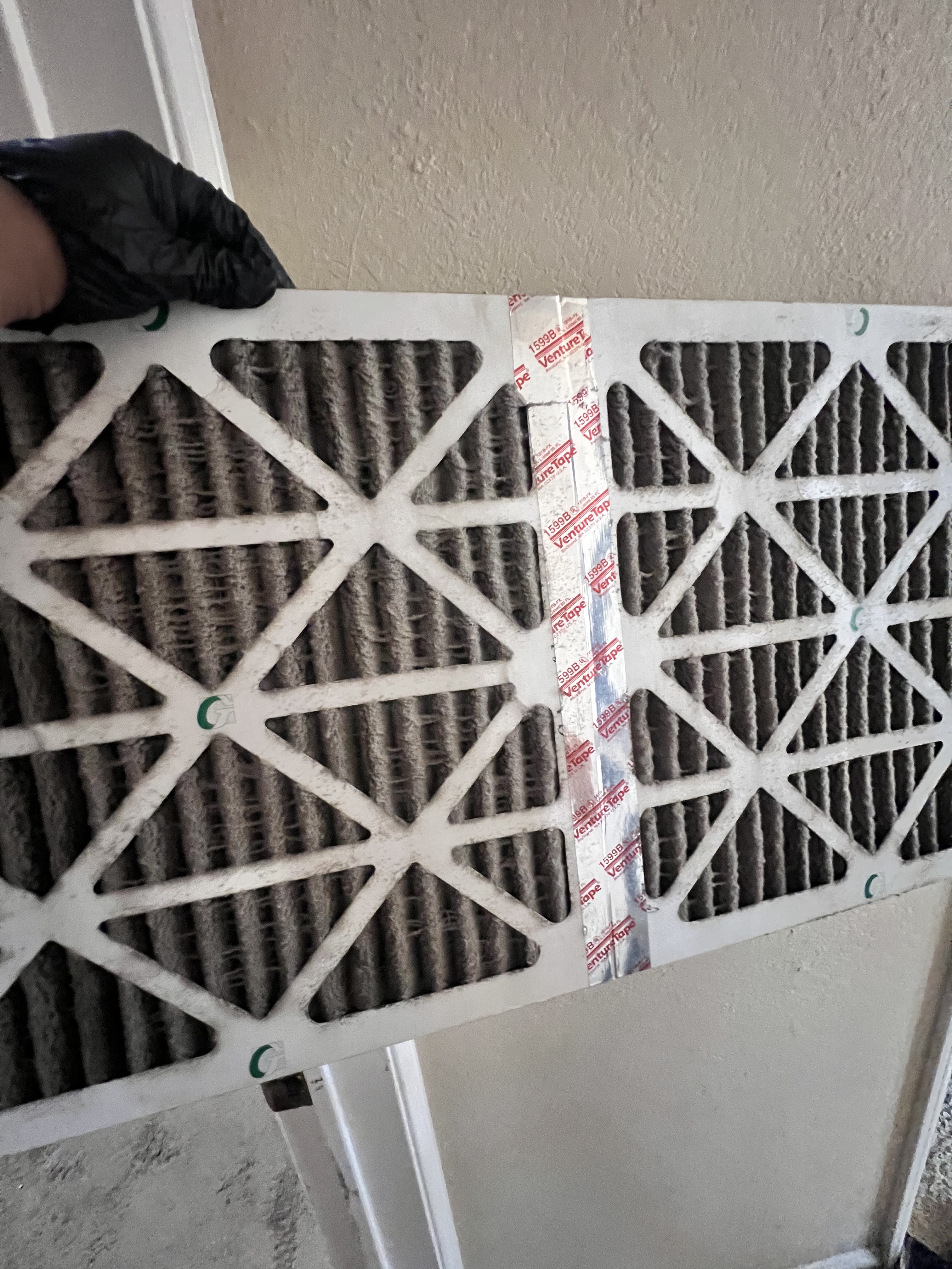 VORXS technician swapping a clogged HVAC air filter during a summer no-cool call