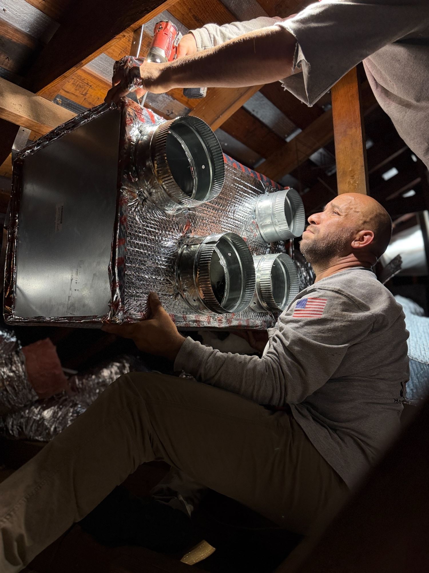 VORXS HVAC technicians installing a custom insulated supply plenum in an Orange County attic