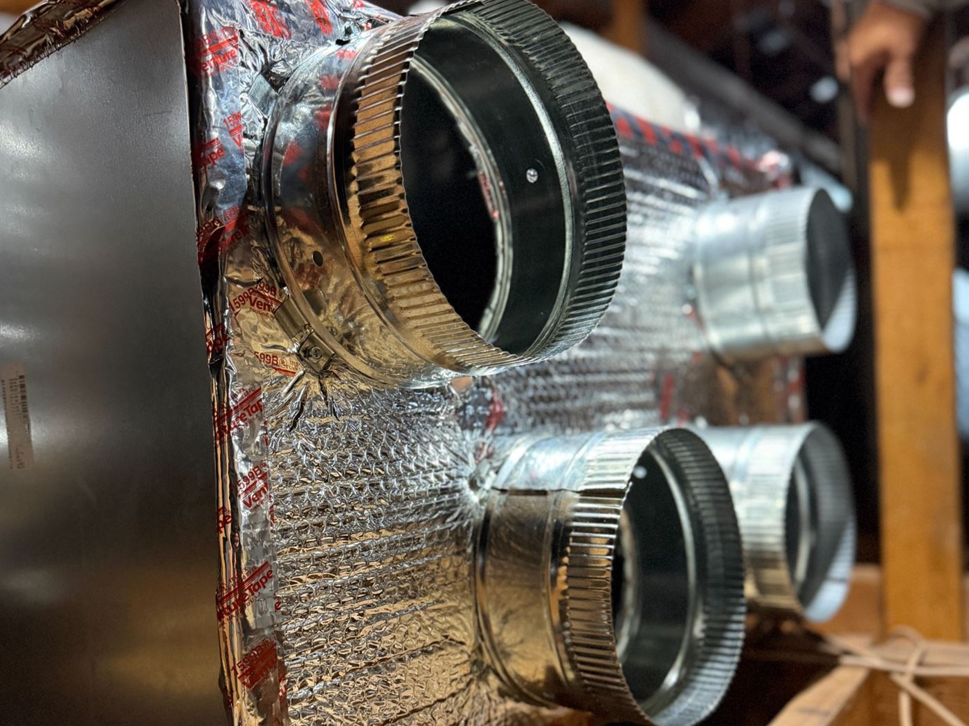Custom insulated HVAC supply plenum with sealed round duct connections installed by VORXS