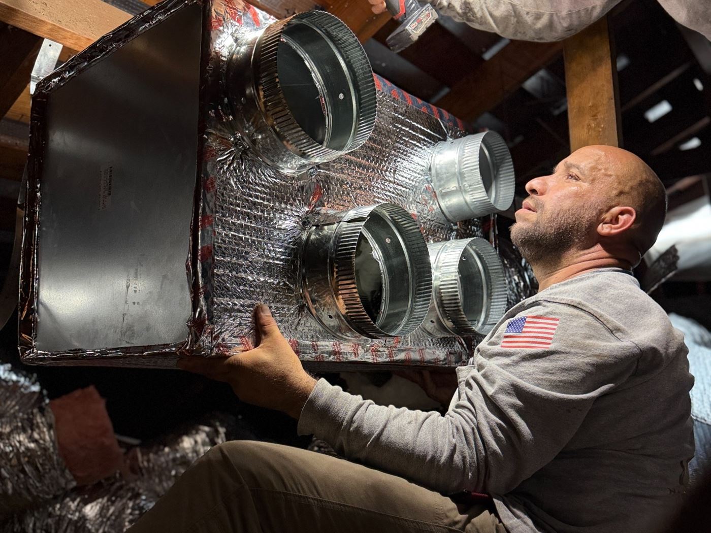 VORXS technician installing and sealing a custom HVAC plenum during an Orange County system installation